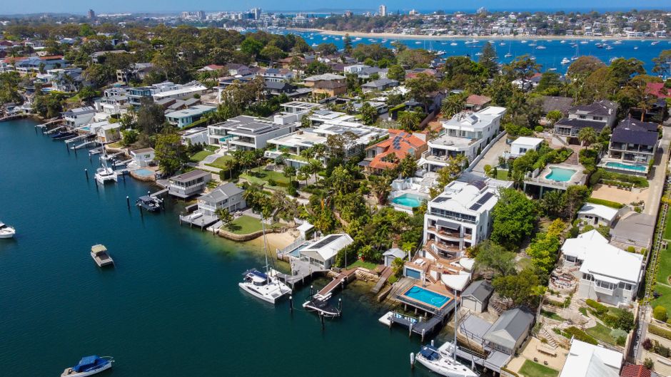 Stunning aerial view of Burraneer Bay, displaying luxury homes along the coastline in summer.